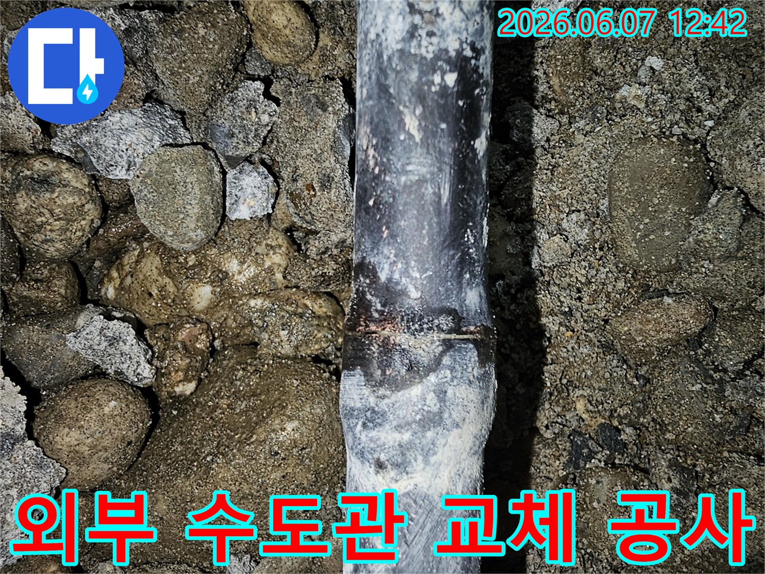 독산동-외부-땅속에-묻힌-수도관에서-발견된-누수-지점을-엔지니어가-확인하고-교체-공사하는-사진
