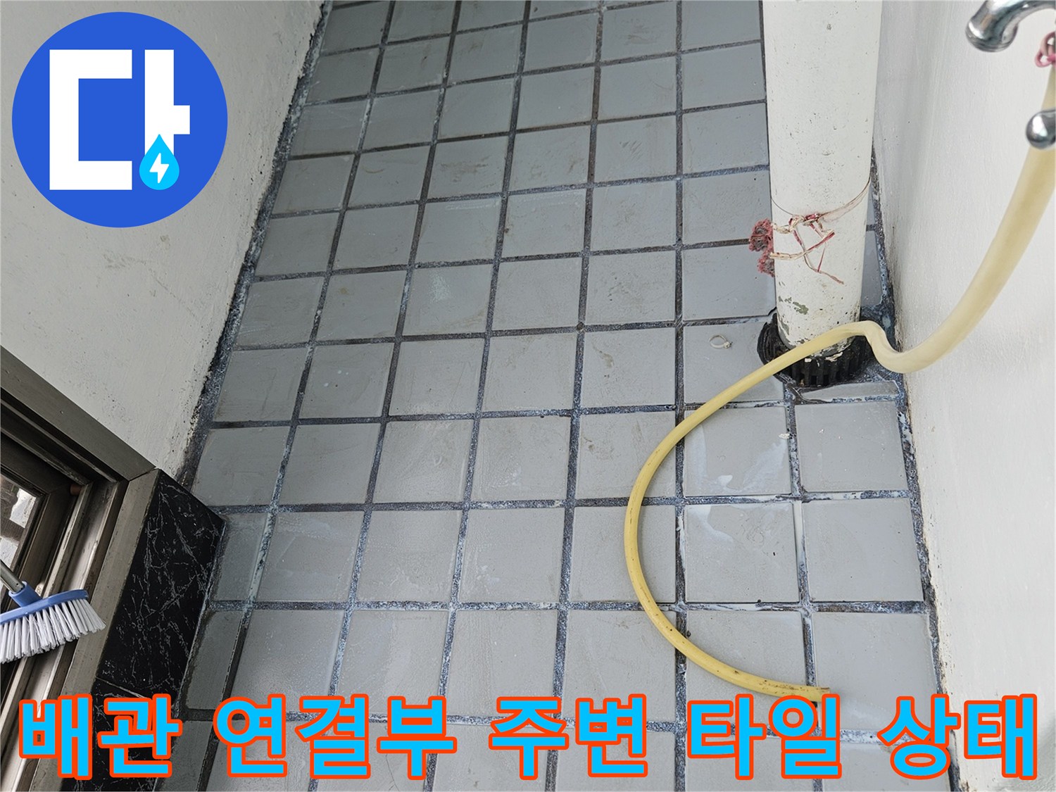 하얀색 PVC 배관과 회색 타일 바닥의 접합 부위 상세 사진