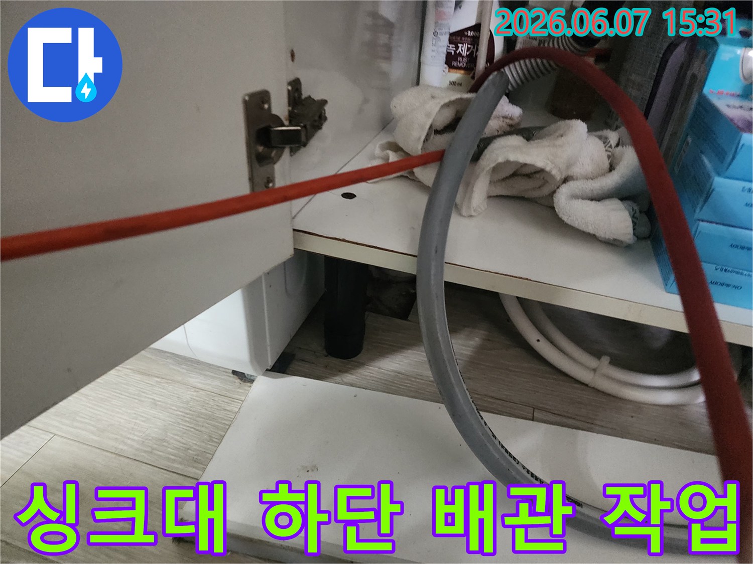 싱크대 밑 배관 주변의 작업 장비와 소품들