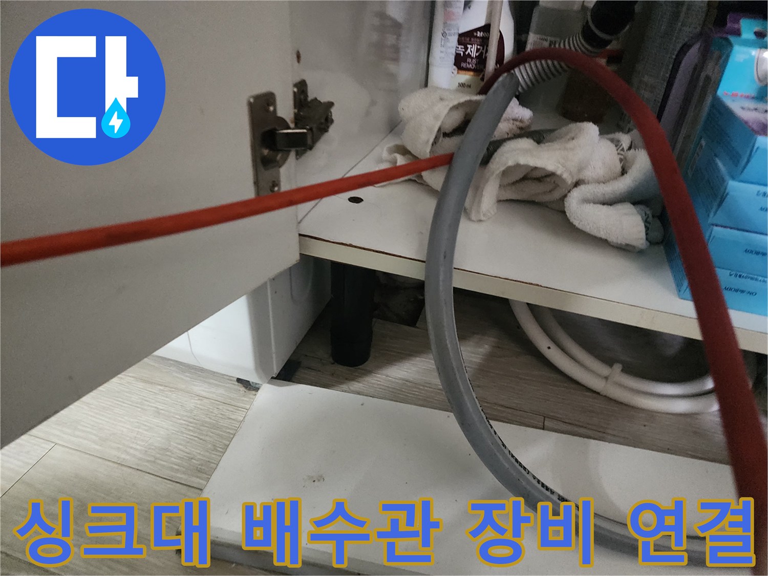싱크대 하단 배관에 연결된 작업 케이블 및 장비