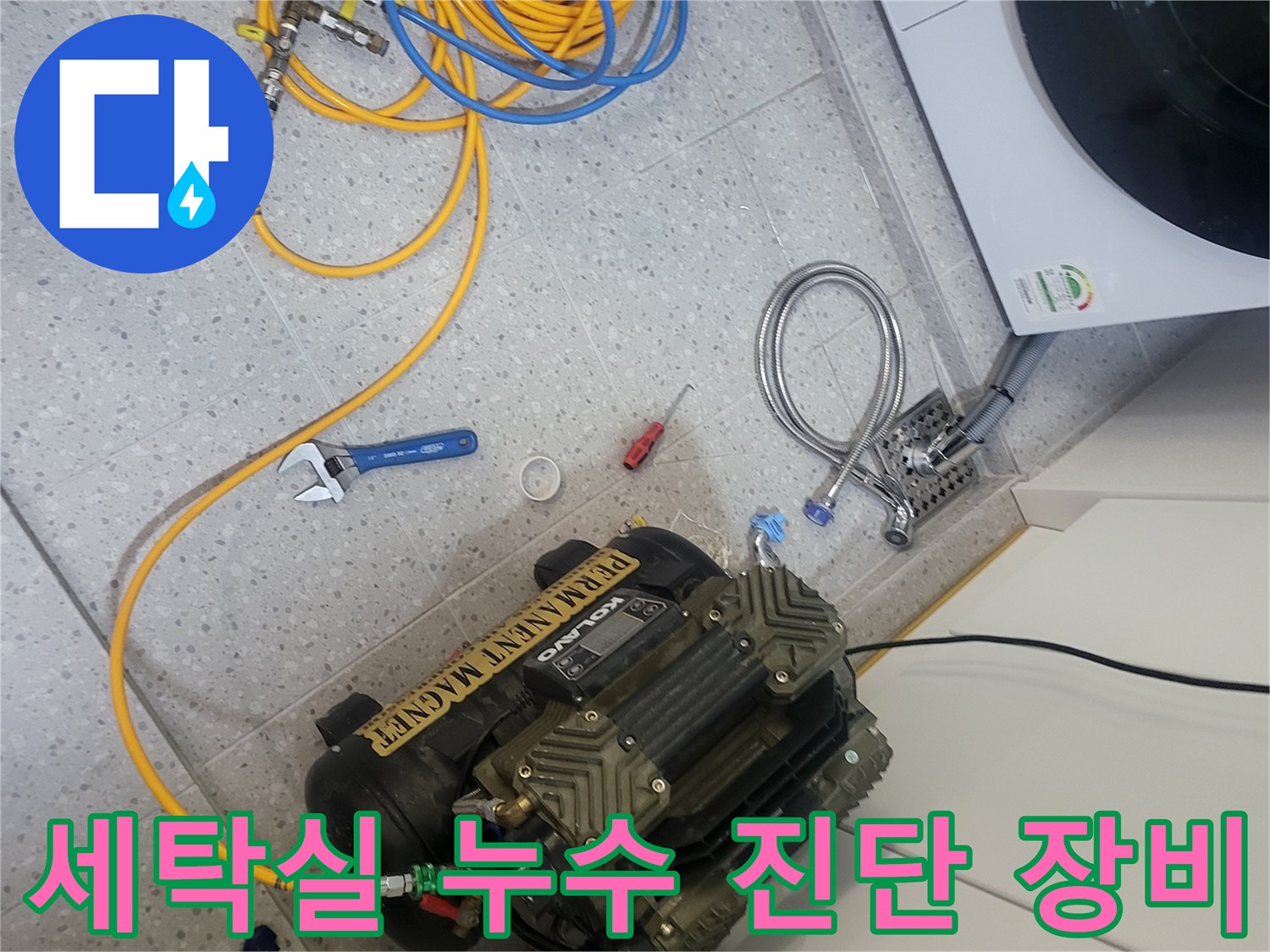 세탁실 바닥에 배치된 공압 테스트용 에어 컴프레셔와 연결 호스