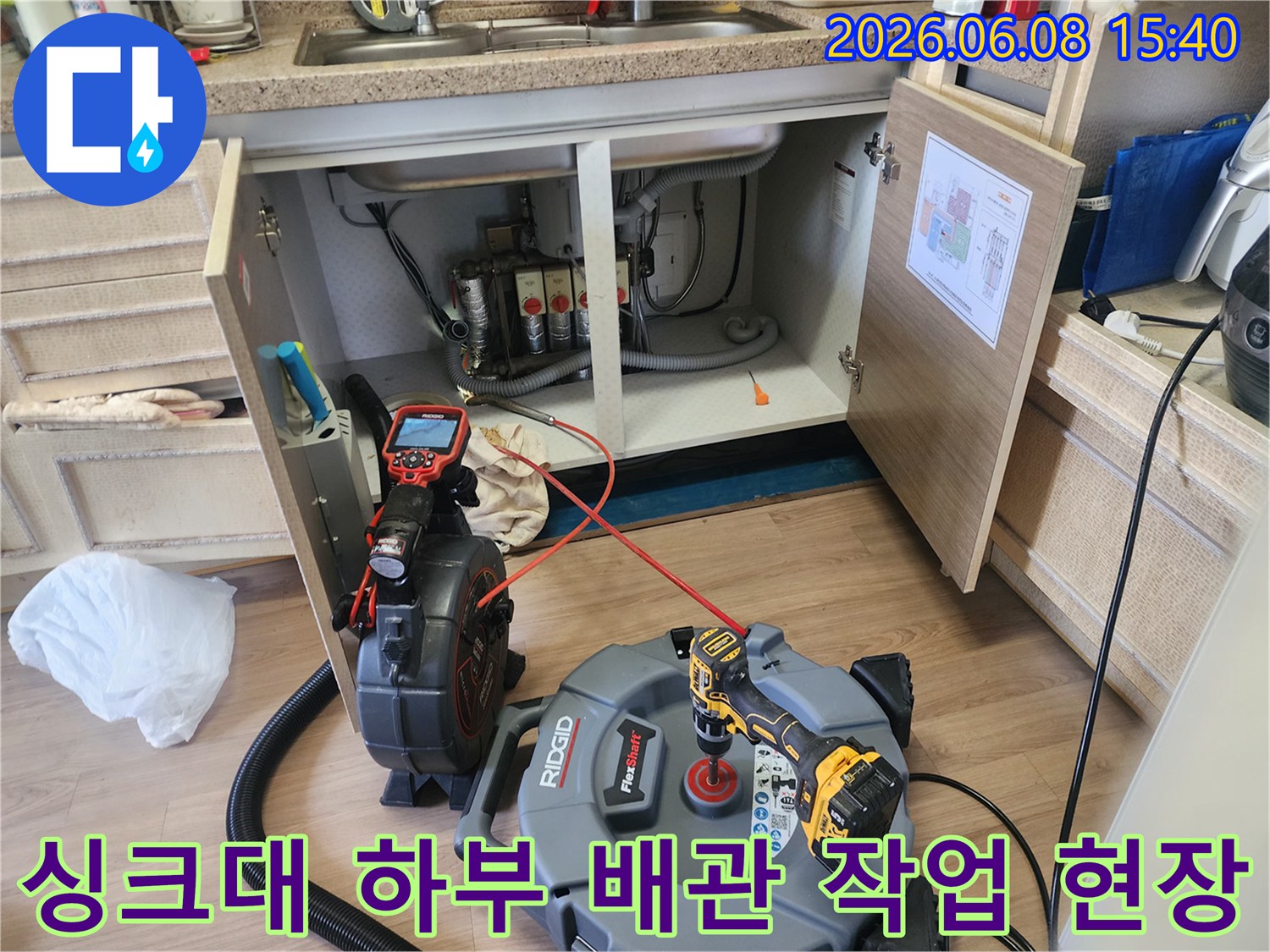 싱크대 아래 배관 청소를 위해 배치된 전문 장비 세트