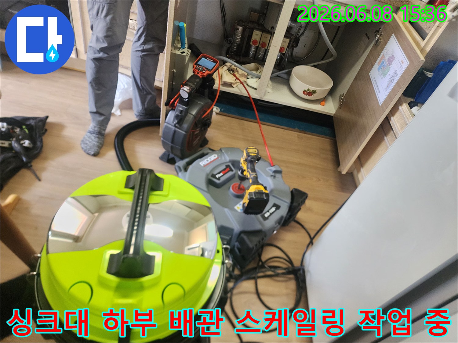 싱크대 하부장 내부에서 진행되는 배관 스케일링 장비와 석션기 모습