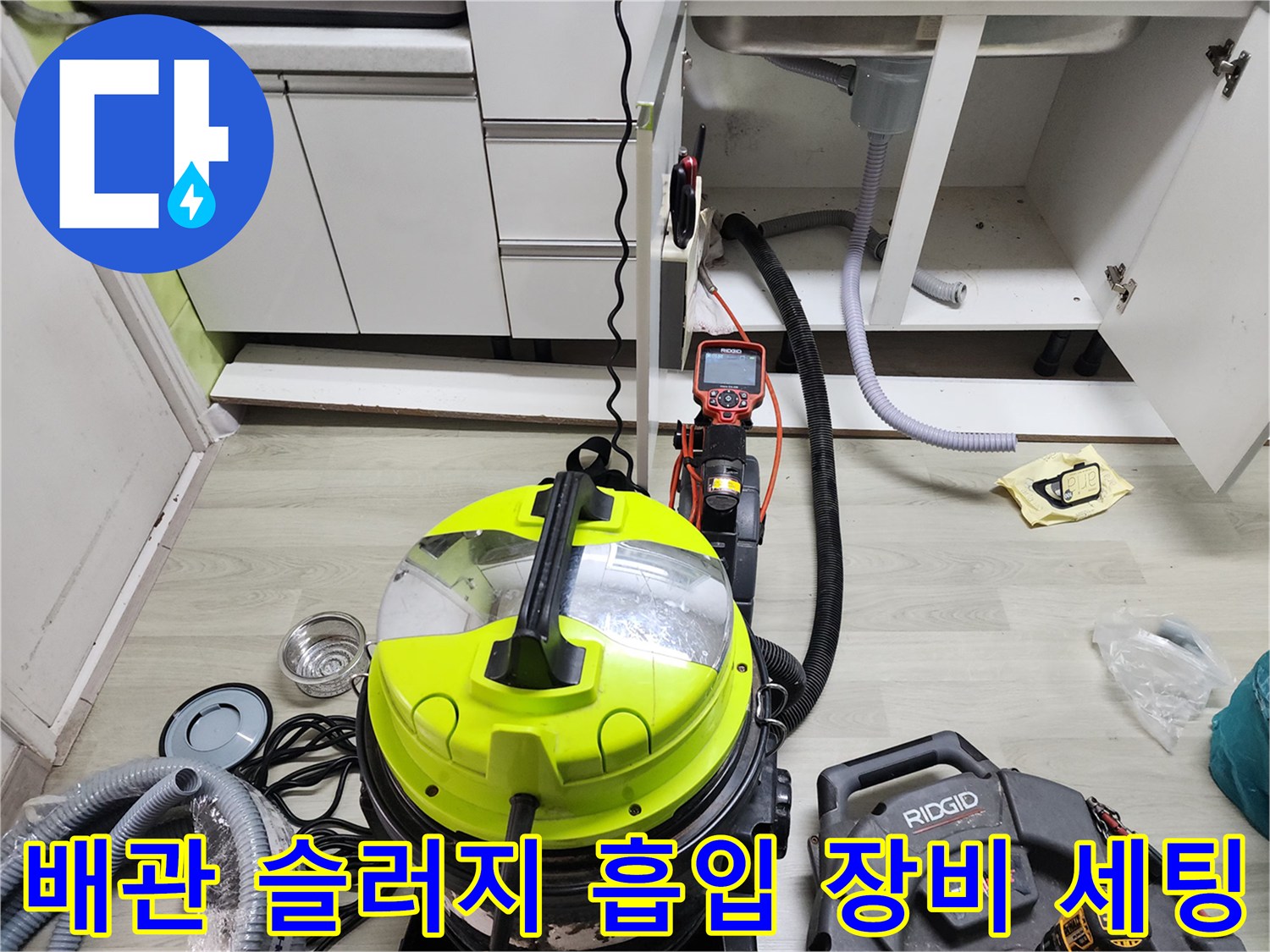 바닥에 놓인 노란색 석션기와 배관 연결 호스 및 작업 도구들