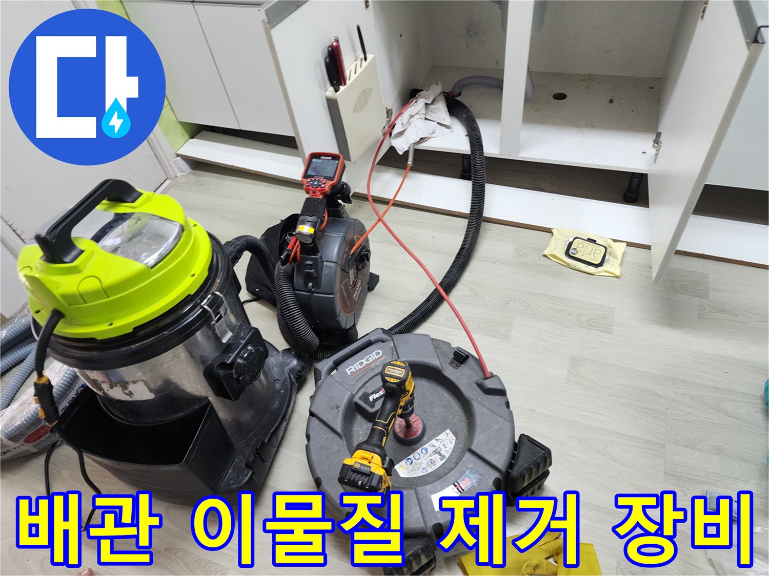 싱크대 아래 하수구 작업을 위해 설치된 석션기와 전동 드릴