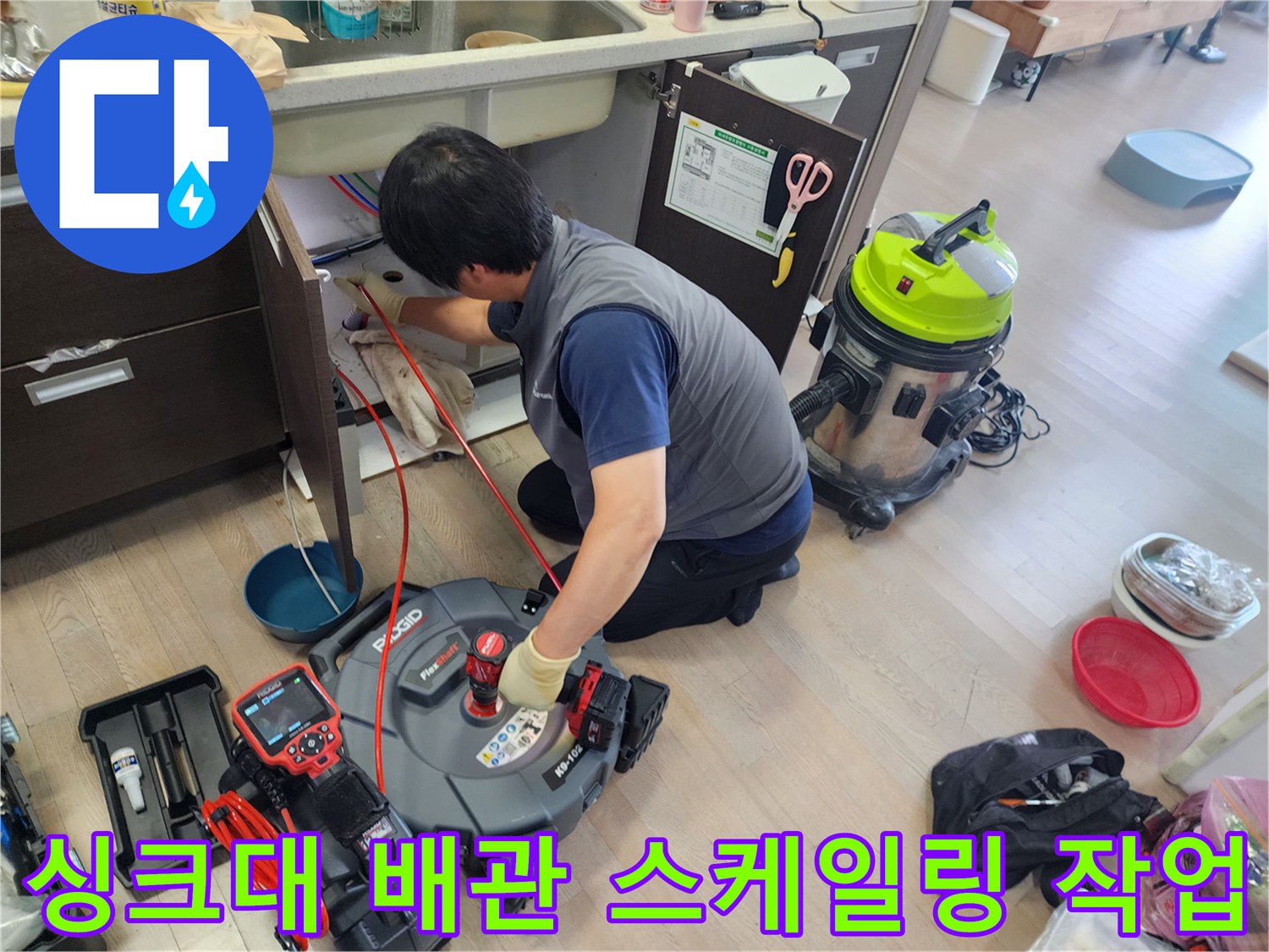 싱크대 아래 배관 내부의 기름 슬러지를 제거하기 위해 장비를 사용하는 모습