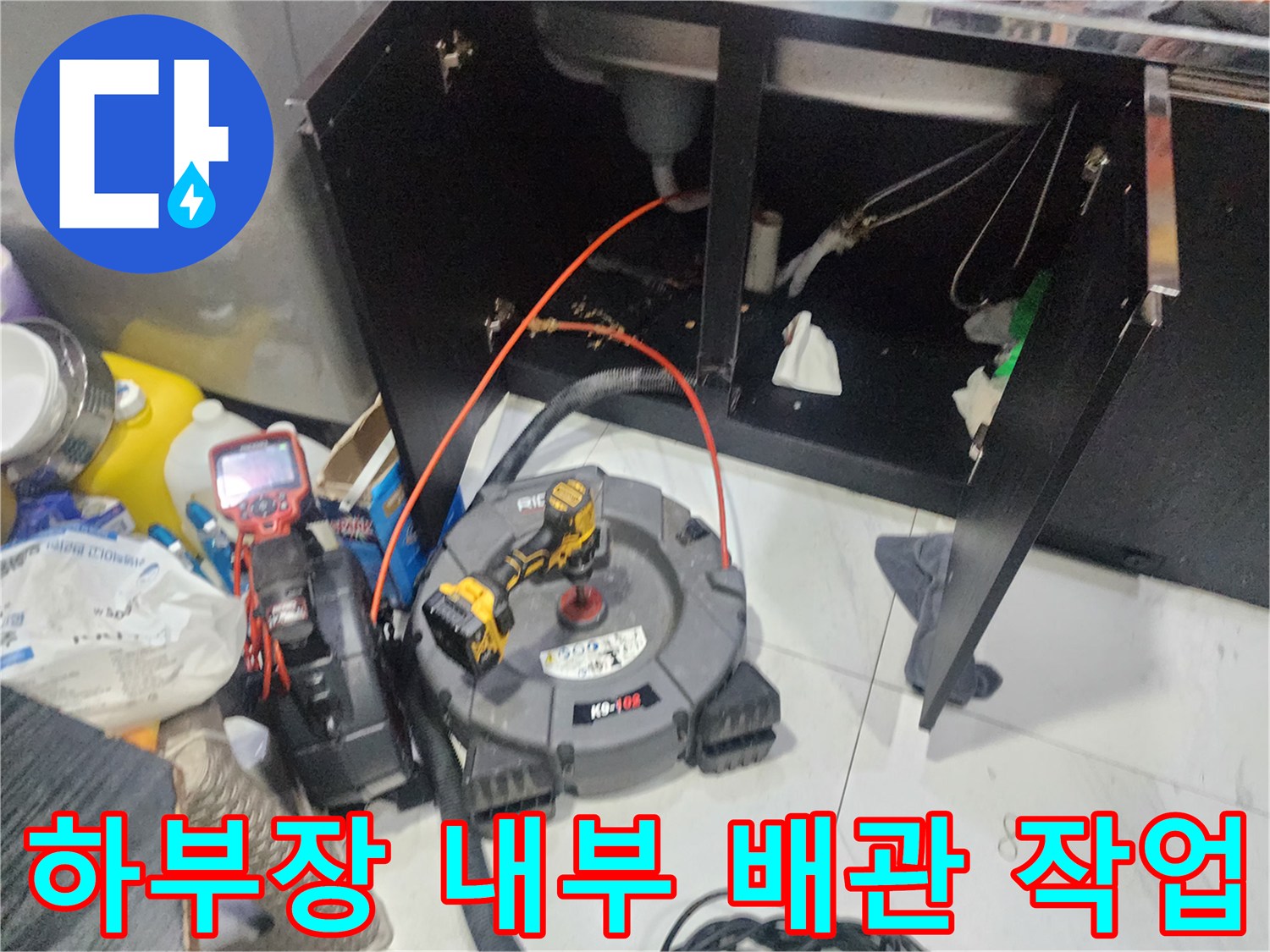 싱크대 밑 공간에서 진행 중인 배관 내시경 점검 및 장비 배치