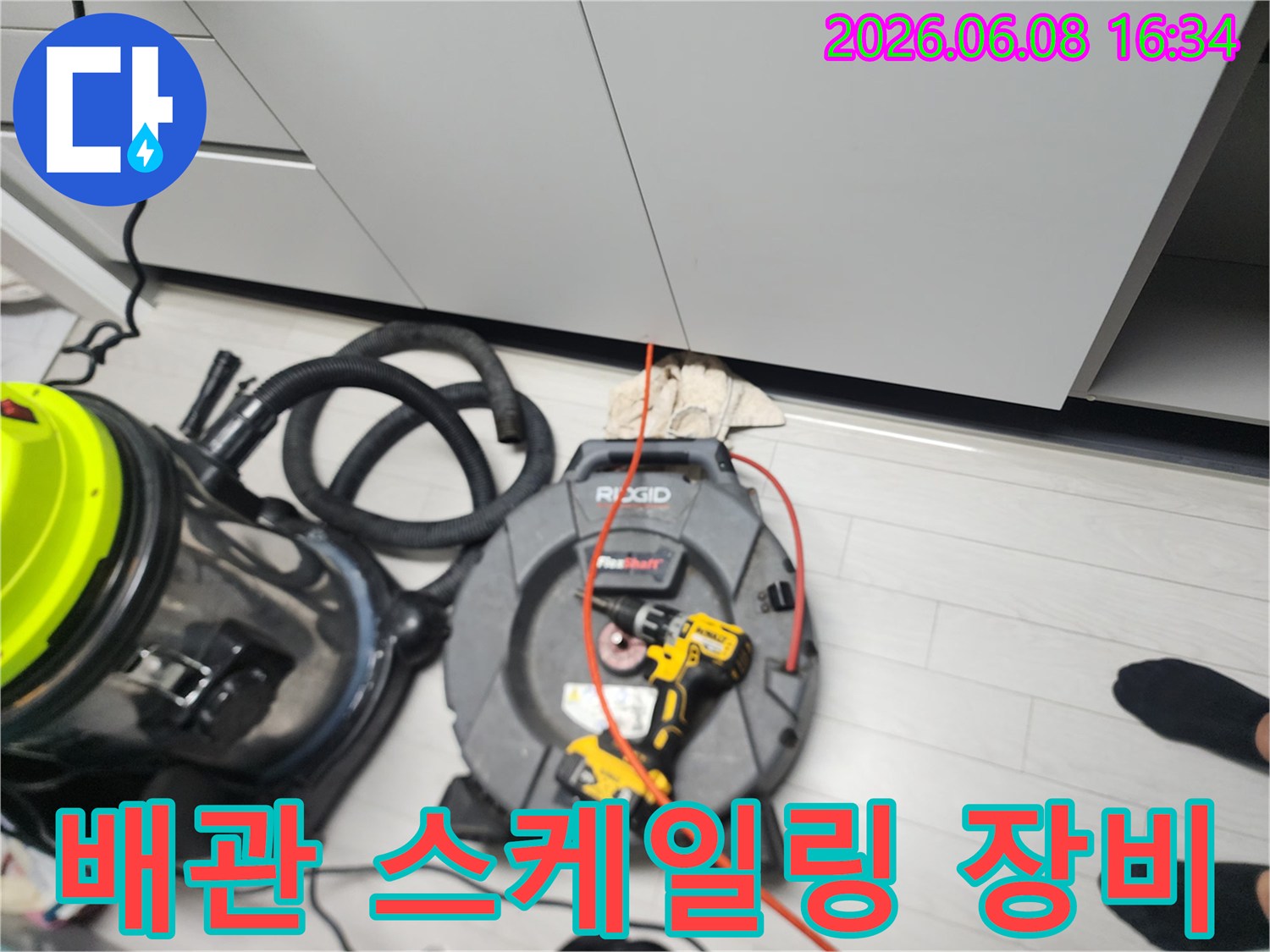 싱크대 하부장 아래 배치된 배관 스케일링 전문 장비와 석션기