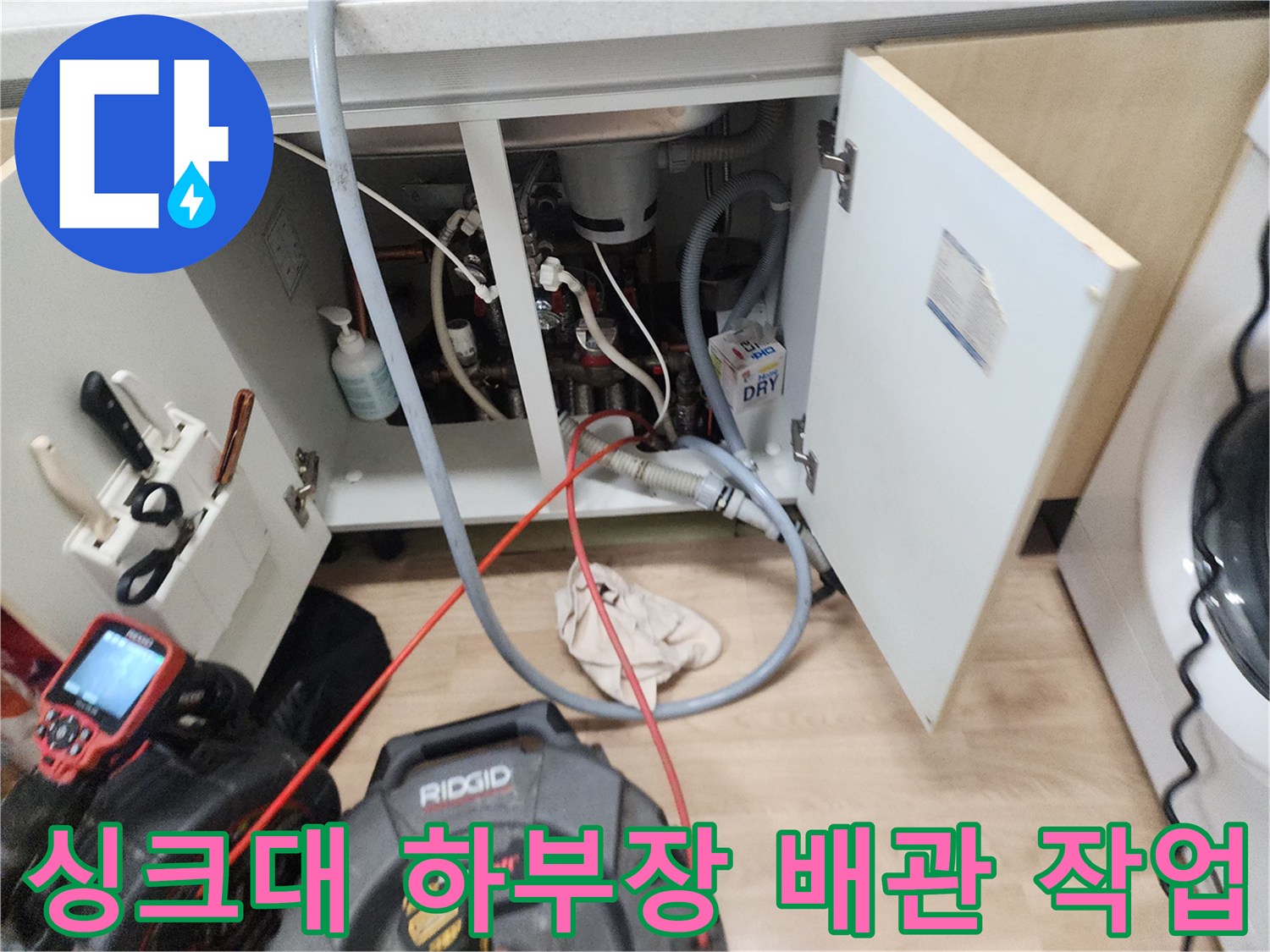 남양주 평내동 주방 싱크대 하부장 내부의 복잡한 배관과 작업 장비 모습입니다.