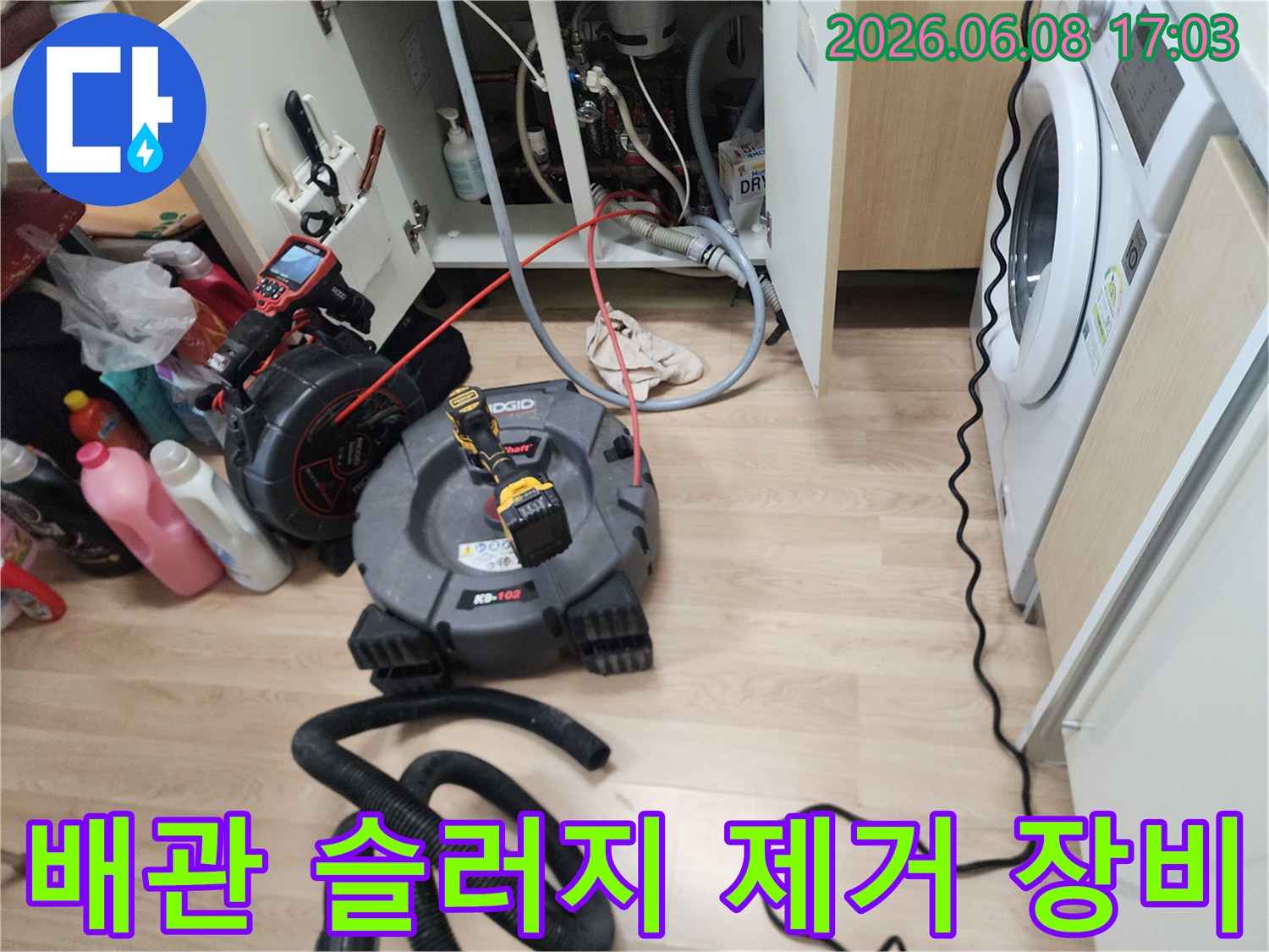 싱크대 하단 배관 청소를 위해 배치된 전문 스케일링 및 석션 장비