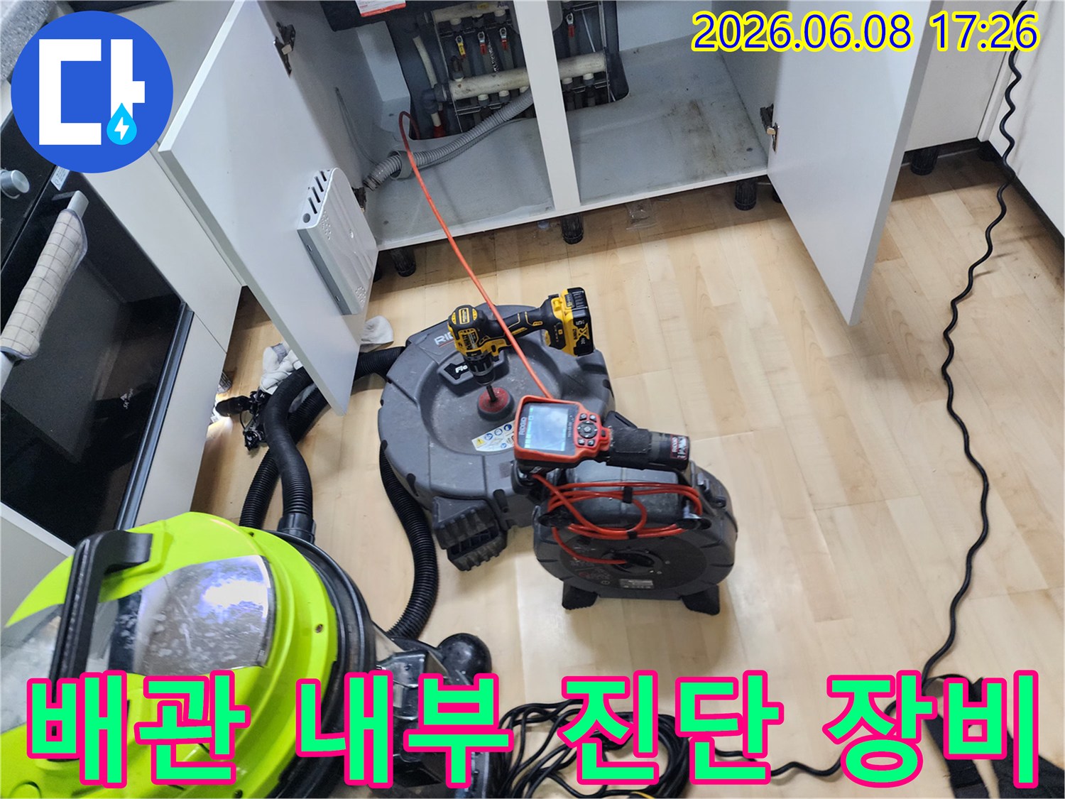 싱크대 하단 배관 점검을 위해 배치된 내시경 모니터와 전동 드릴 장비