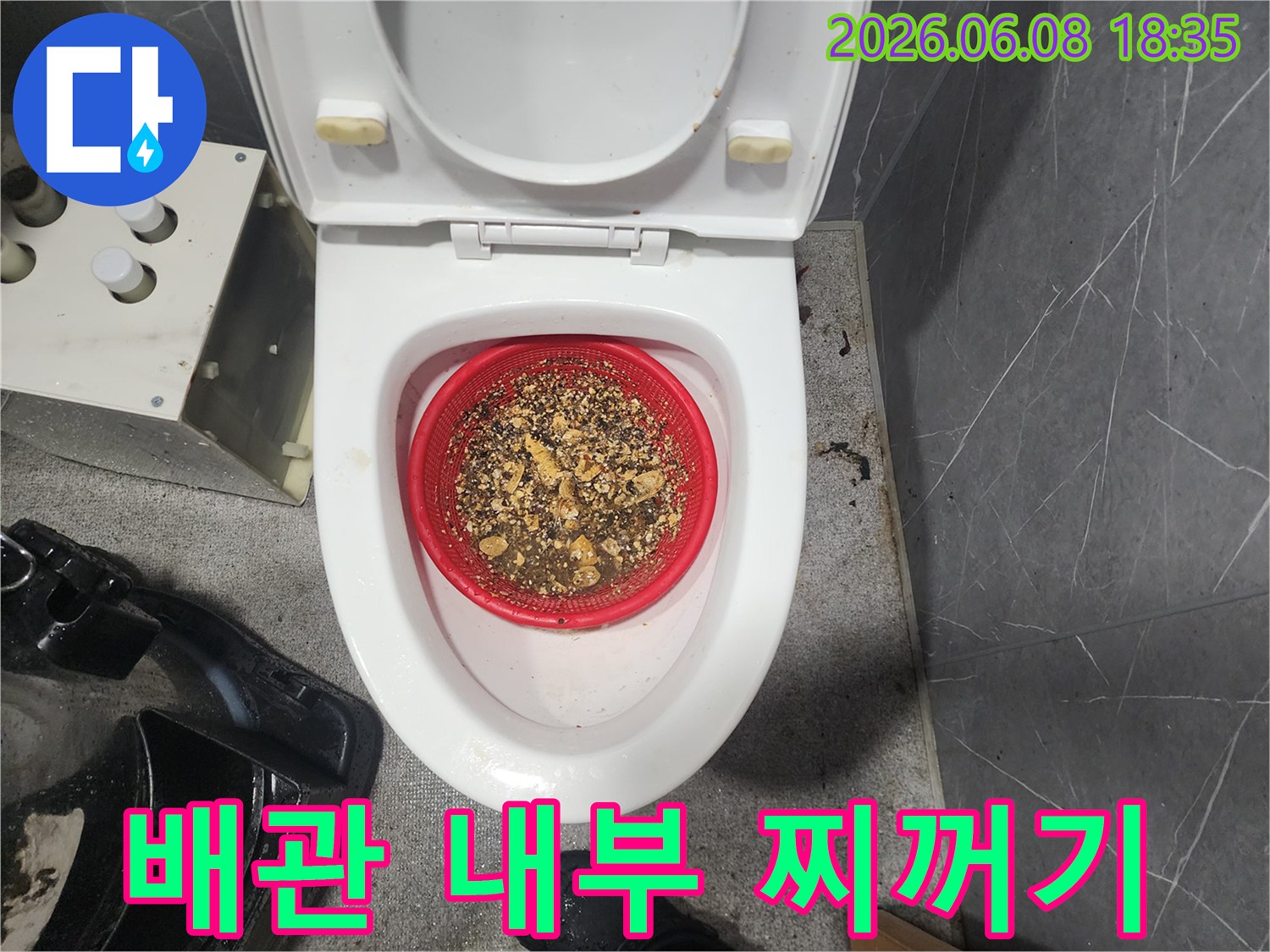 변기 위 빨간색 체에 걸러져 있는 배관 스케일링 부산물
