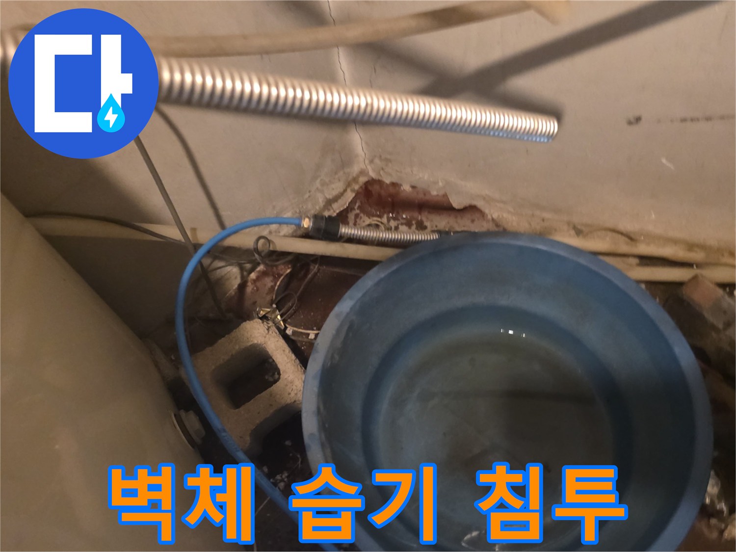 균열된 벽면 사이로 스며든 물과 고인 물 양동이