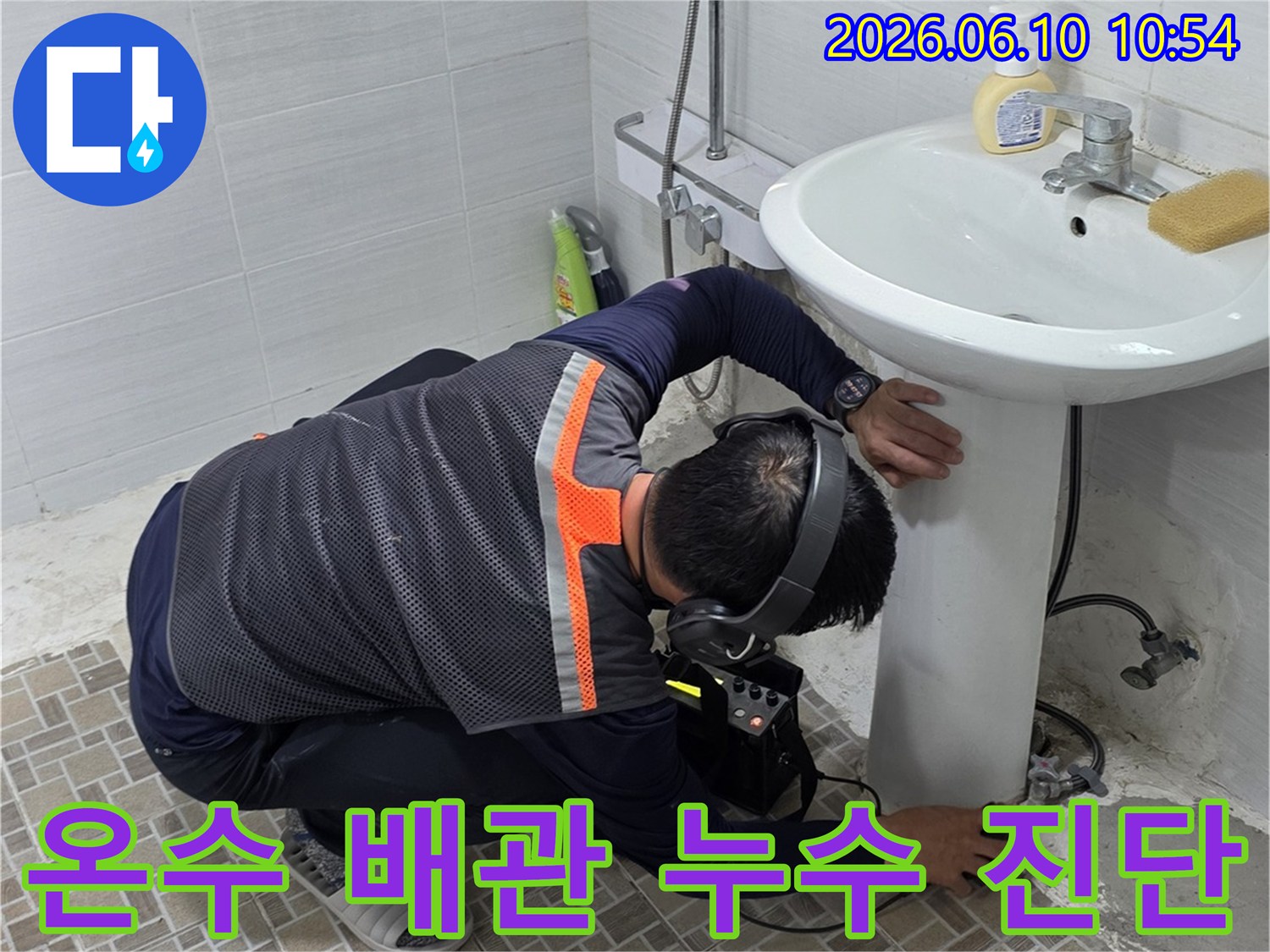 욕실에서-온수 배관의 누수 지점을-정밀하게 진단하기 위해-누수탐지 장비를 사용하는-전문 엔지니어의 모습
