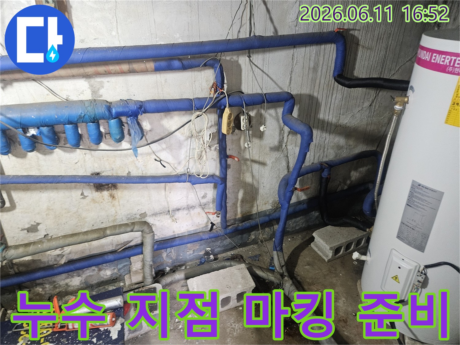 파란색 보온재 배관들 사이로-누수 지점을 표시한-현장의 모습이며-수리 준비가 진행 중입니다