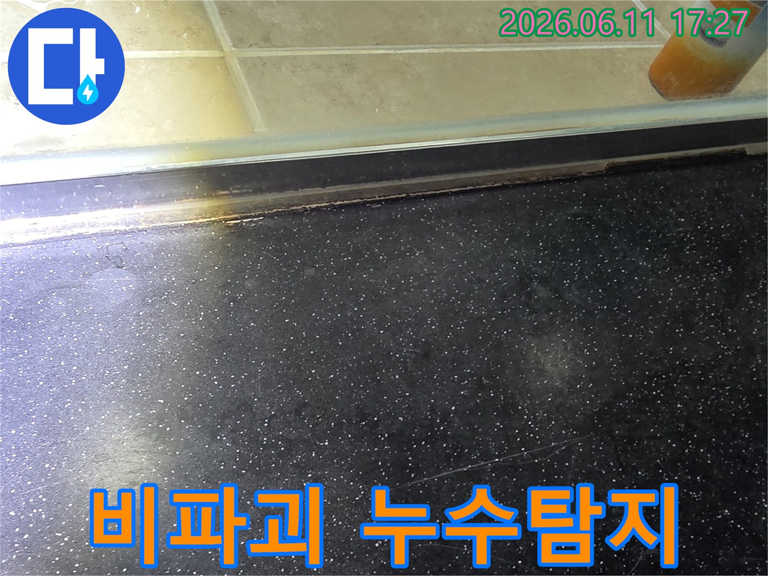 욕실 샤워부스-하단에서-전문 장비를-활용하여-비파괴 방식으로-누수를-탐지하는-모습입니다