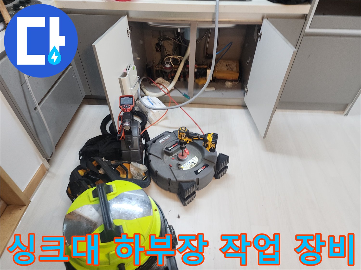 식사동 싱크대 하부장 내부의 배관 점검을 위해 배치된 내시경과 청소 장비들입니다.