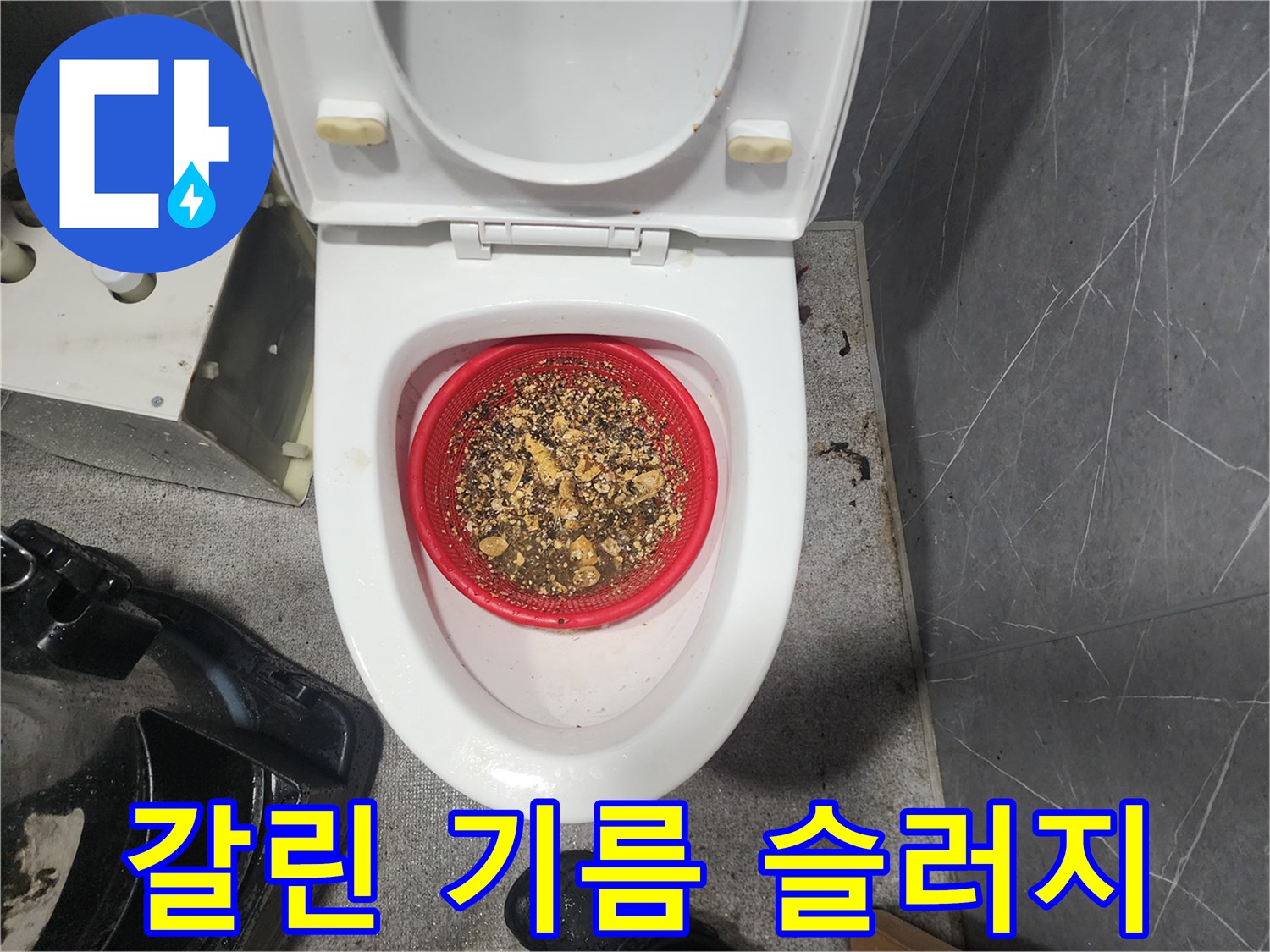 배관 청소 후 붉은 용기에 모인 갈색 기름 덩어리들