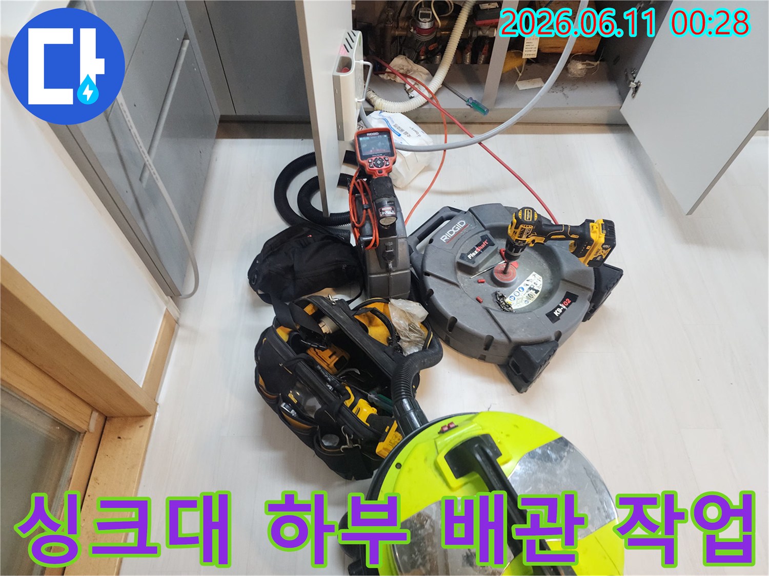 싱크대 아래쪽의 복잡한 배관 부위를 청소하기 위해 준비된 전문 장비들입니다.