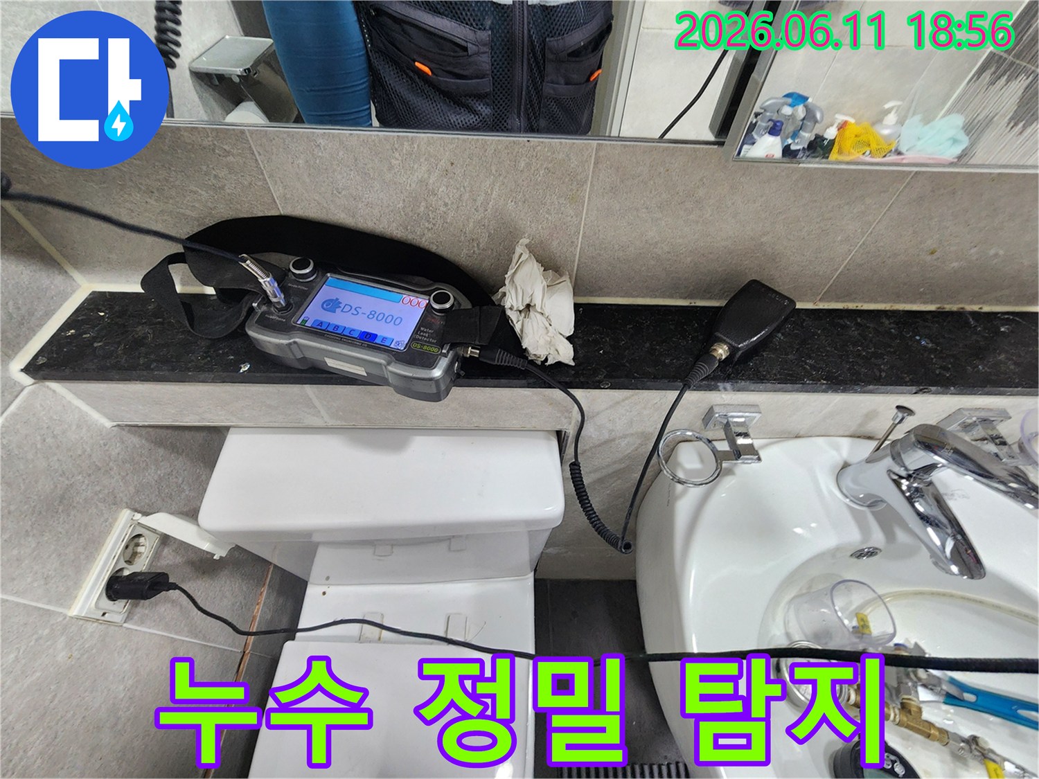누수-엔지니어가-화장실-배관의-누수-지점을-정밀하게-탐지하기-위해-청음-장비를-사용하여-탐지하는-모습