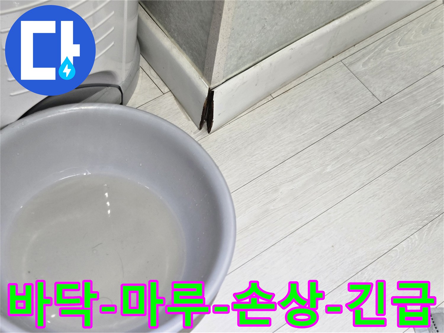 물에 젖어 변색된 마루 바닥과-물을 받아내는 대야가 놓여있는-심각한 누수 현장의 모습