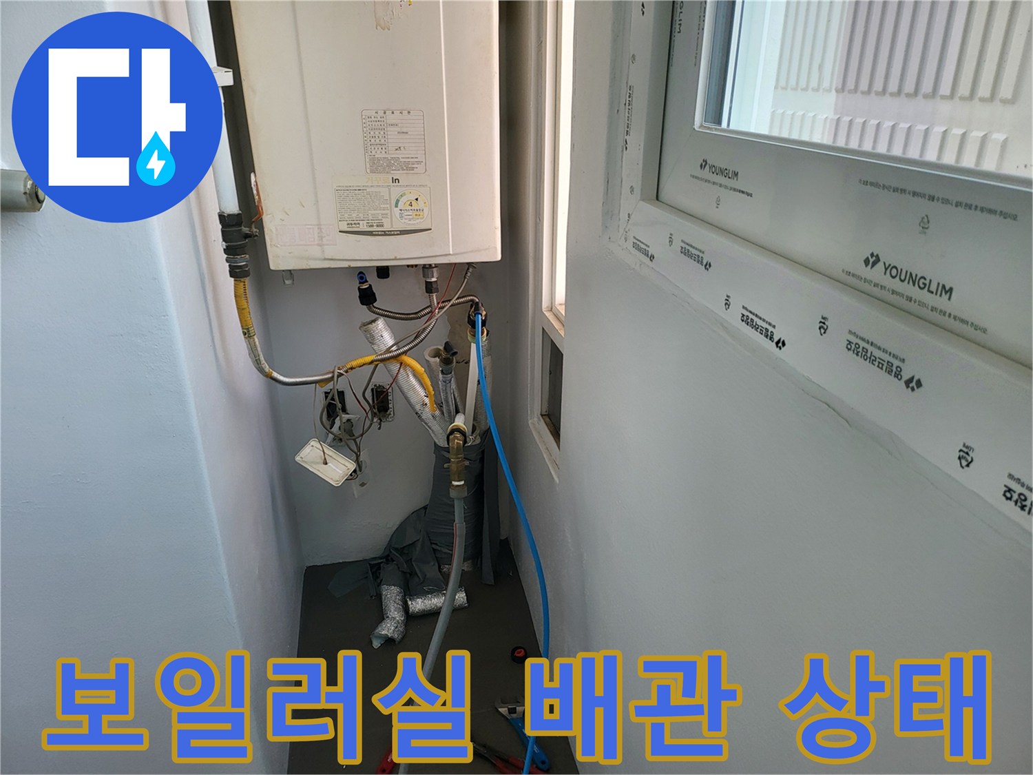 보일러 하단에 연결된 여러 개의 급수 및 온수 배관 모습