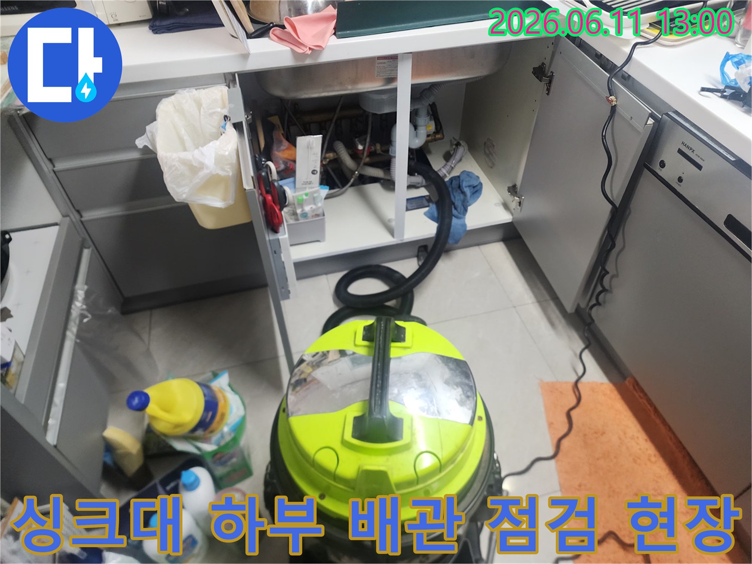 정리된 싱크대 하단 배관과 작업용 청소기 배치 상태
