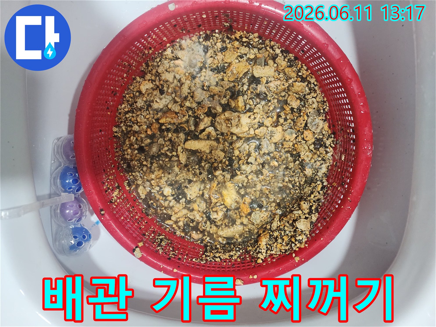 붉은 채반에 모인 배관 스케일링 후의 기름 슬러지 조각들