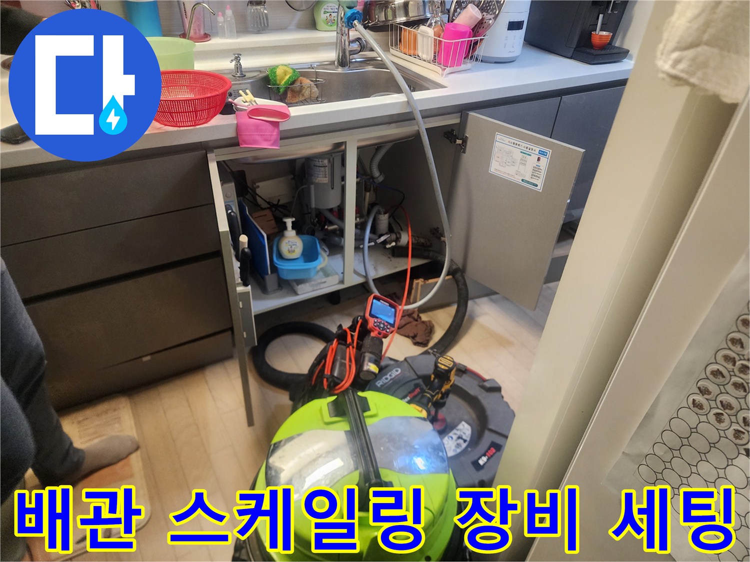 주방 싱크대 하단 배수구 통로를 청소하기 위해 준비된 전문 장비들