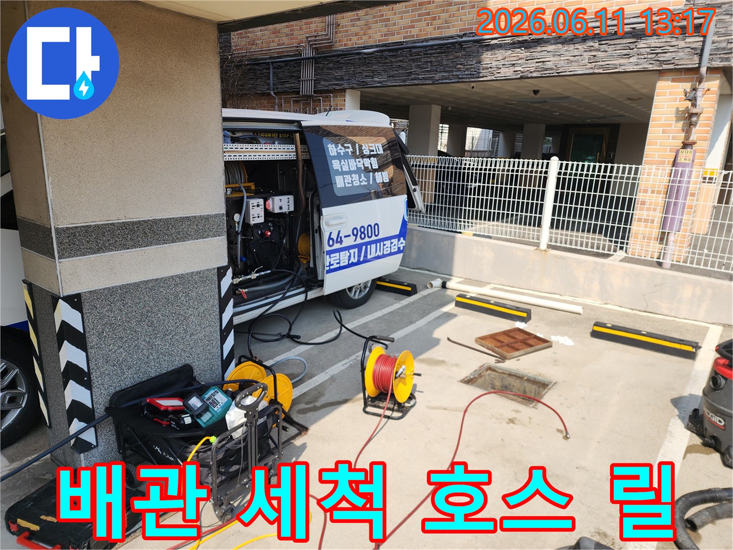 노란색 호스 릴과 고압 세척기 장비가 있는 작업 현장