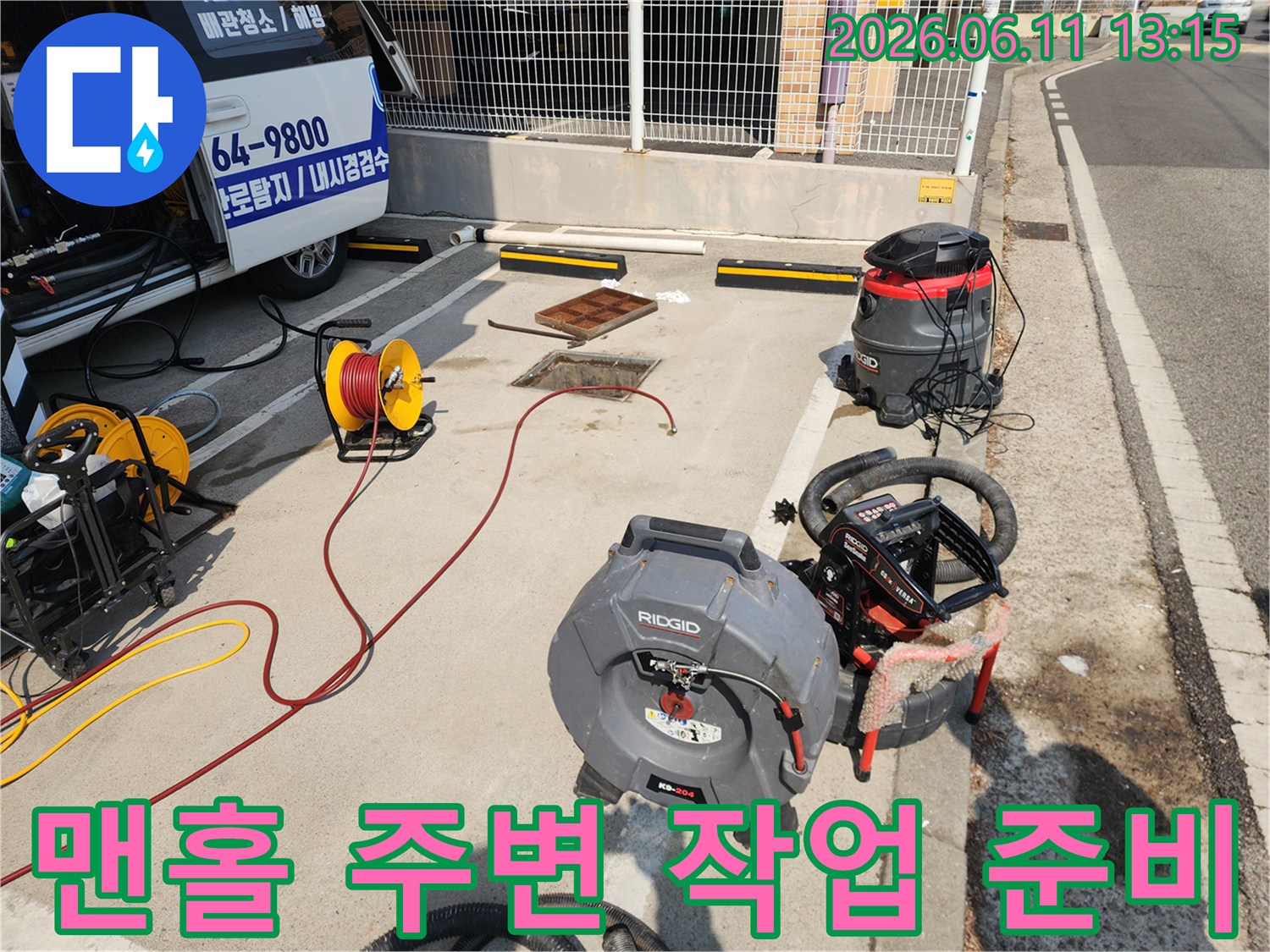 맨홀-덮개-옆에-나열된-배관-세척용-전문-장비들