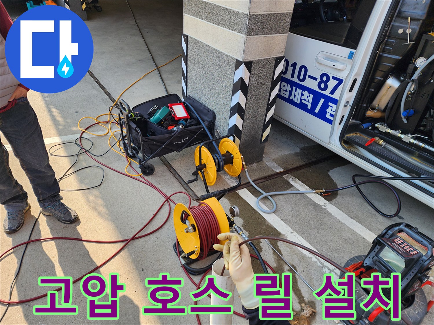 작업을 위해 바닥에 배치된 고압 세척용 호스 릴과 장비함