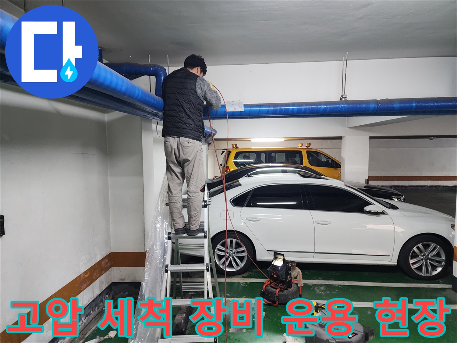 주차장 천장 파란색 배관 아래에서 진행되는 고압 세척 공사