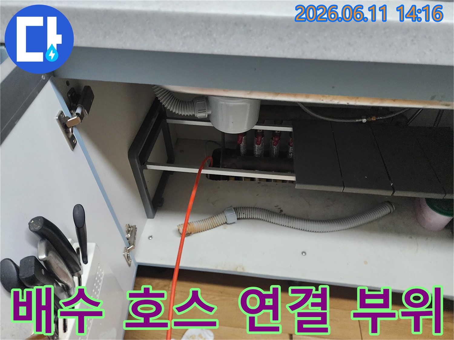 싱크대 하단 배수구와 연결된 회색 주름관 및 배관 구조
