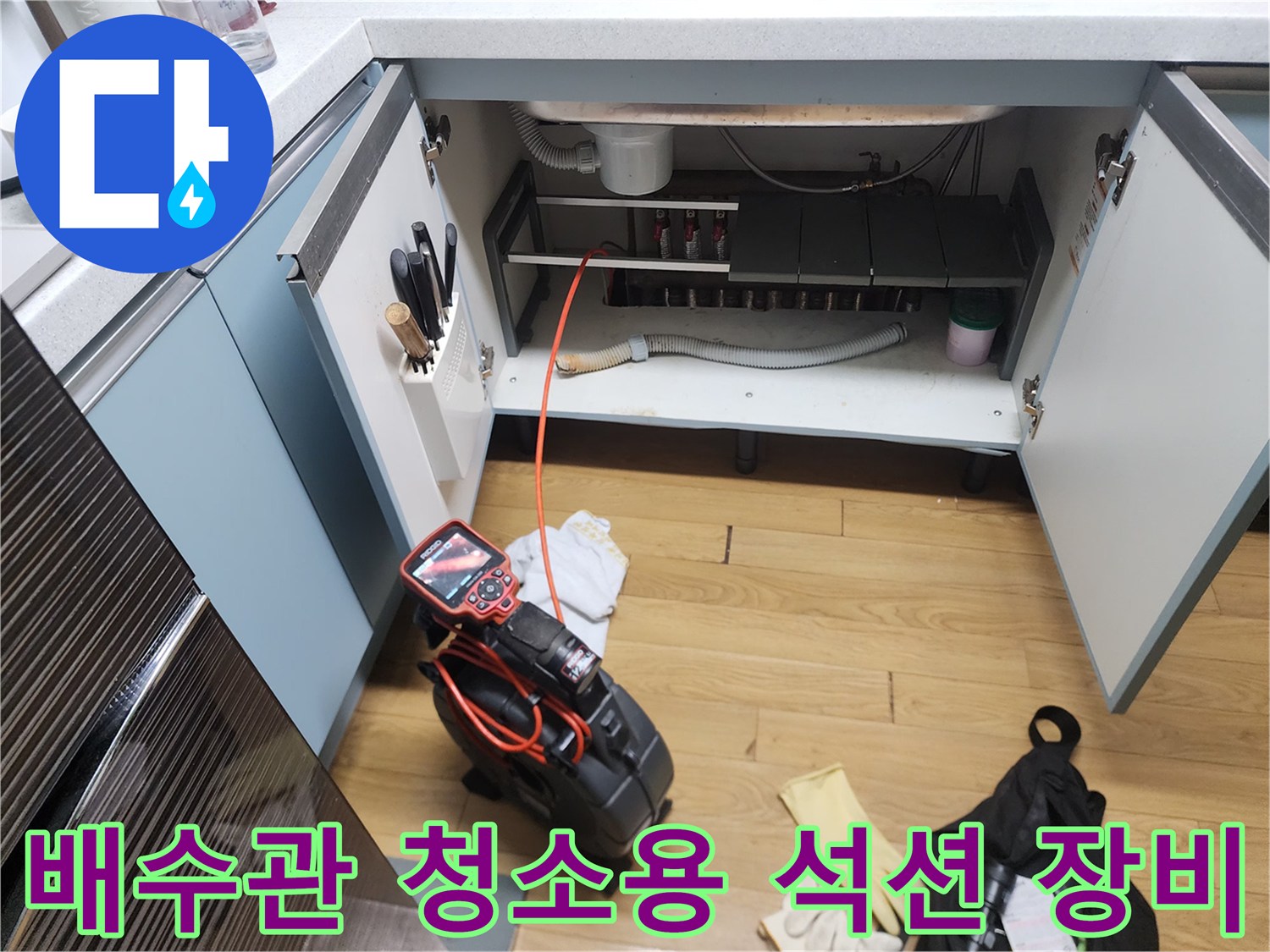 싱크대 하부장 내부 배관 세척을 위해 배치된 전문 장비들