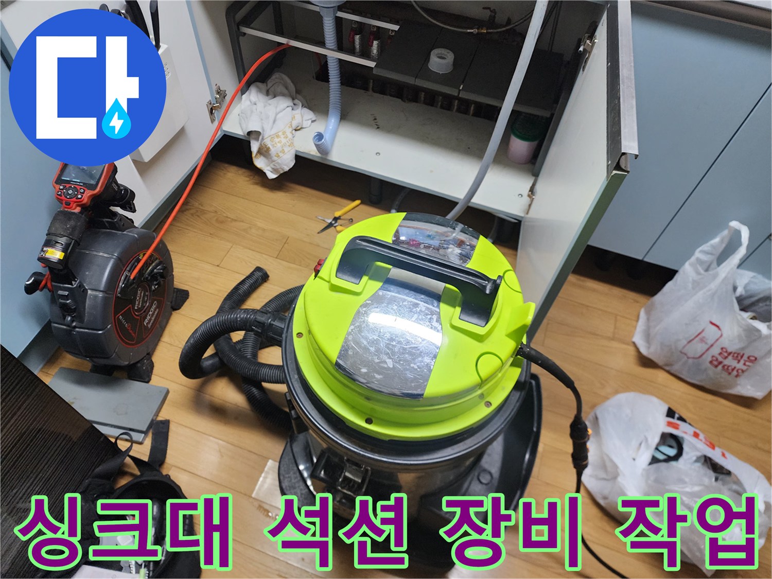 주방 싱크대 하부장 근처에서 진행 중인 강력한 석션 장비의 모습입니다.