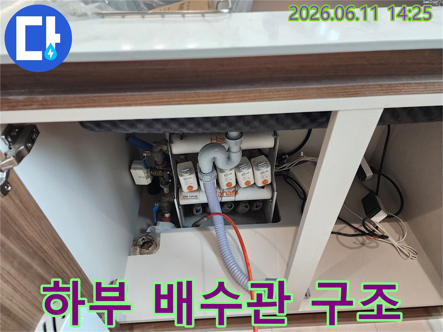싱크대 하단-복잡하게 연결된 배수관과 호스 모습입니다.
