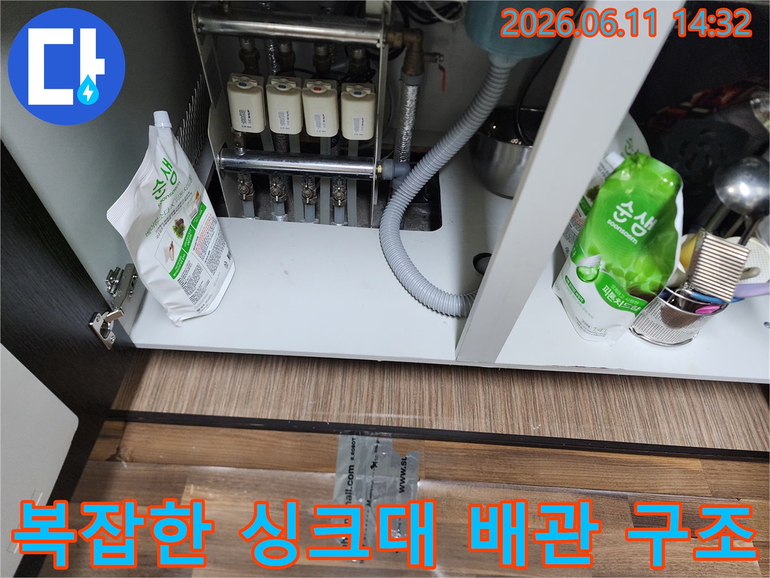싱크대 하부장 내부의 정수 필터와 연결된 밸브 및 호스