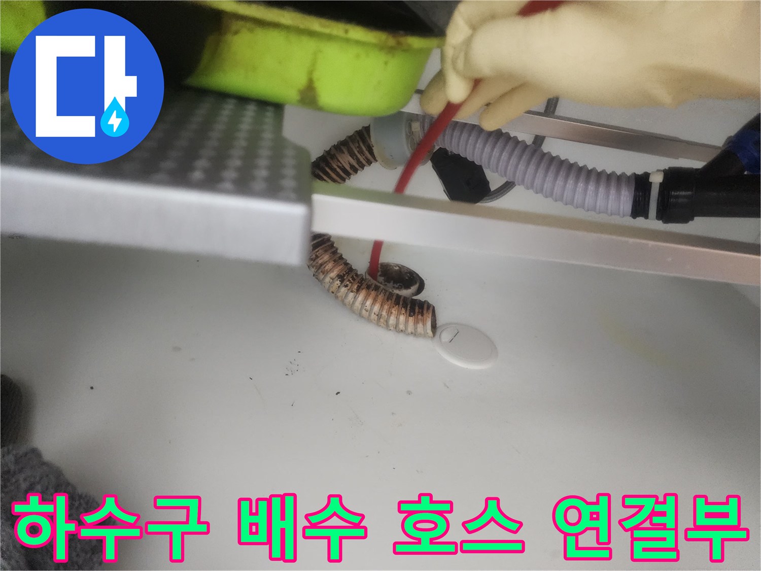 싱크대 아래쪽의 주름진 배수관과 연결된 부품들을 촬영하였습니다.