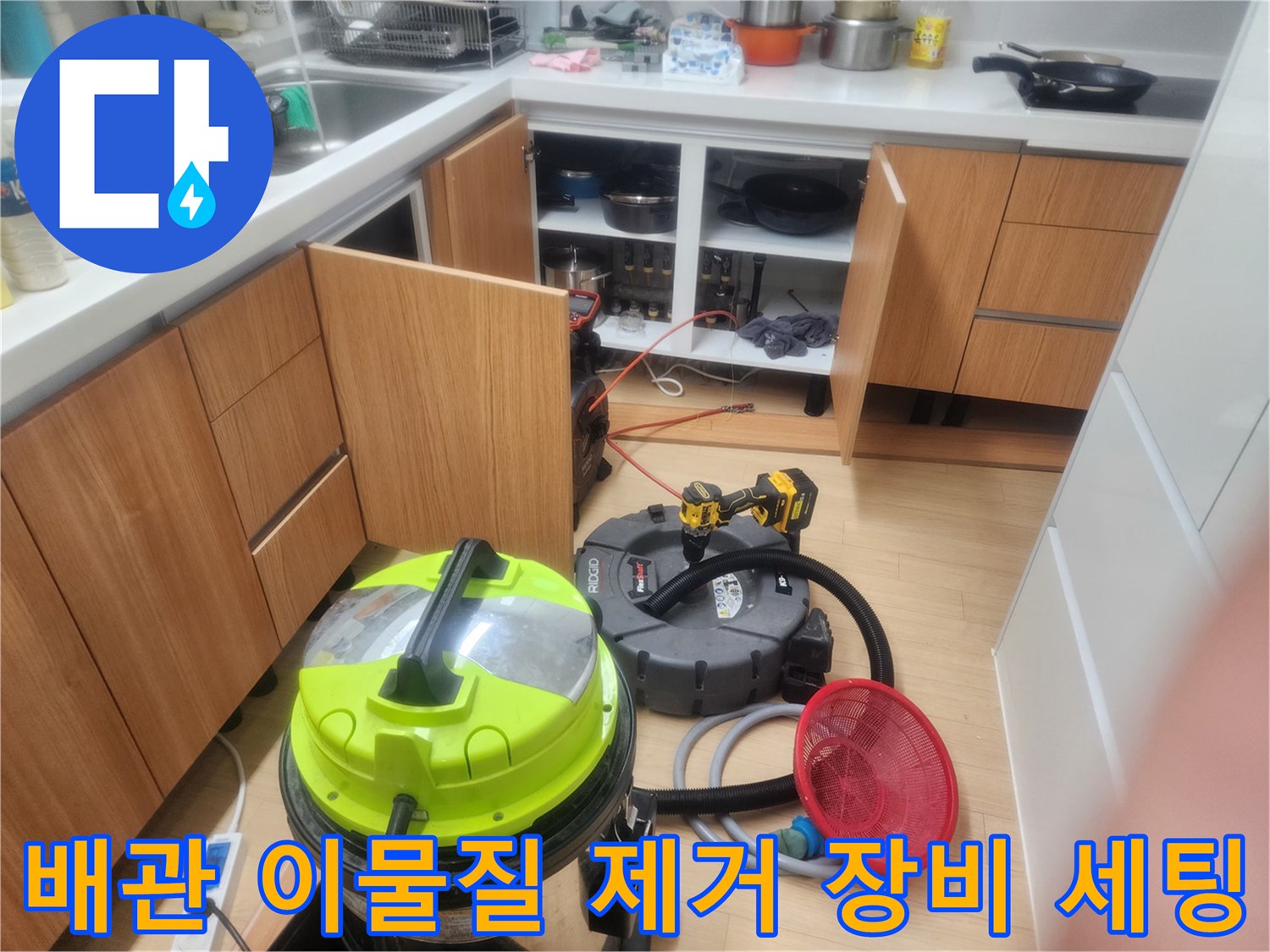 작업 현장 바닥에 배치된 배관 흡입용 청소기와 오물을 거르는 빨간색 망입니다.
