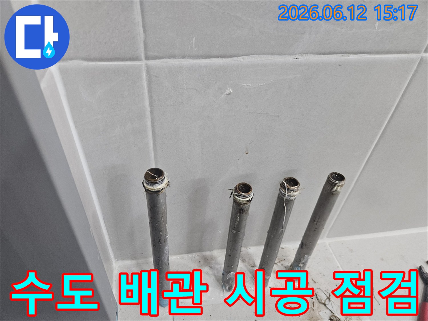 새로운 수전 설치를 위해-벽에서 돌출된 수도 배관의 시공 상태를 점검하는 장면입니다.