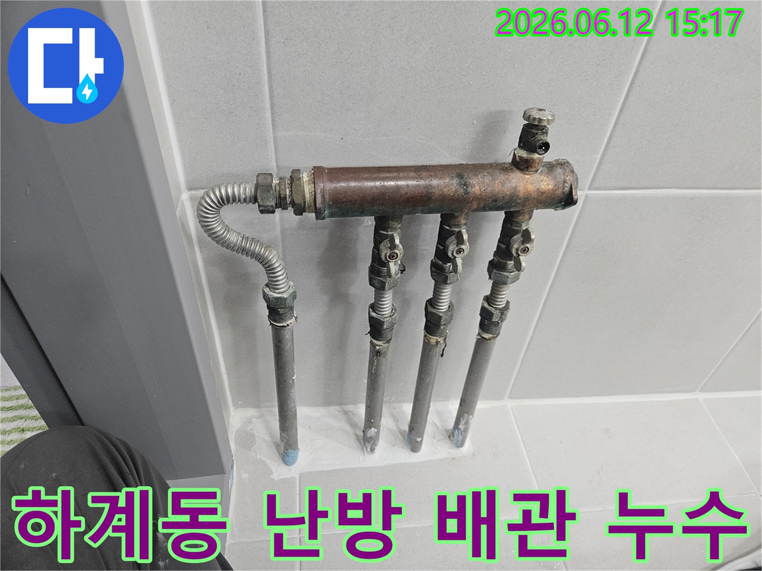 하계동 빌라의 난방 배관 분배기에서 누수 흔적이 발견되어-전문가가 부식된 배관 연결부를 면밀히 점검하는 중입니다