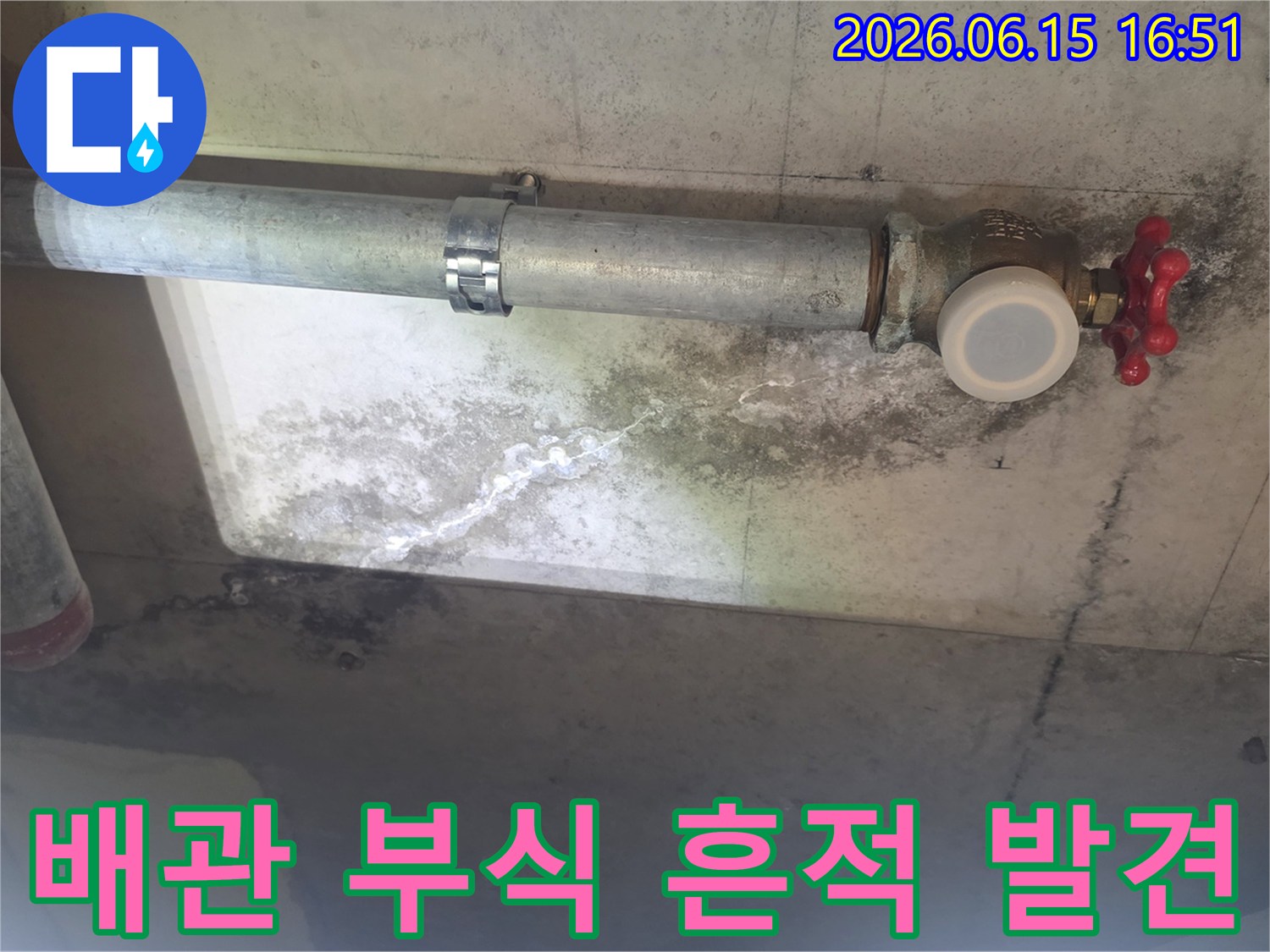 이 이미지는 천장 배관 주변에 생긴 누수로-인한 하얀 석회질 자국과-검은 곰팡이 얼룩을 보여주며-배관의 노후 상태를 나타냅니다