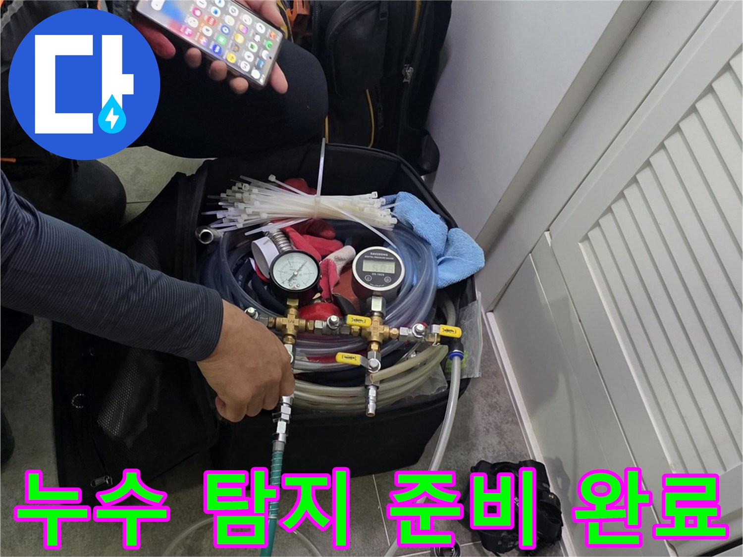 현장에서 누수 탐지 장비를-조작하며-스마트폰으로 데이터를 분석하는 엔지니어