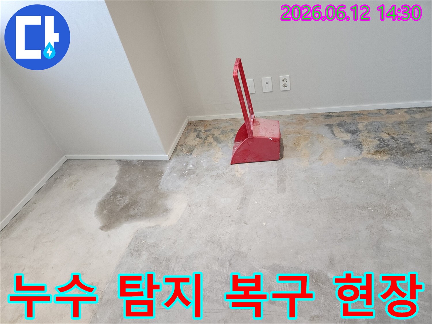 누수-현장에서-콘크리트-바닥이-젖어있고-빨간색-청소-도구가-놓여있는-모습