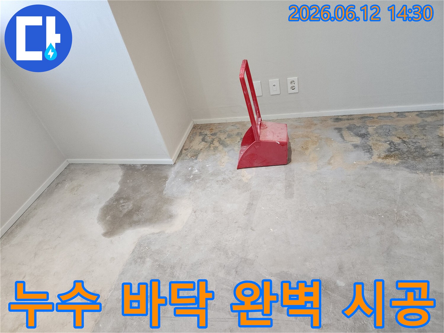 누수-현장에서-콘크리트-바닥이-젖어있고-빨간색-청소-도구가-놓여있는-모습