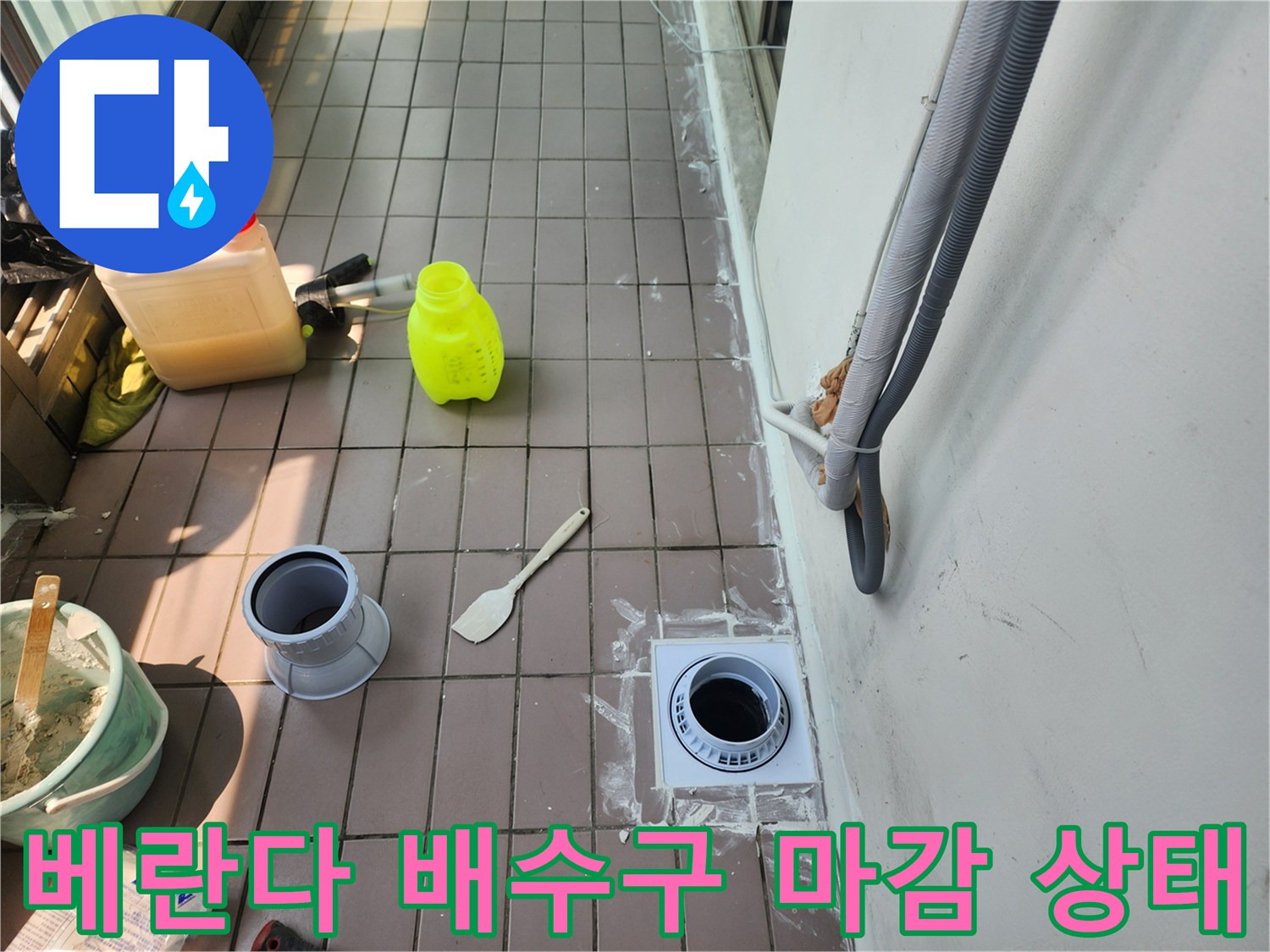 배수구 주변 타일과 배관 입구가 노출된 작업 현장입니다.