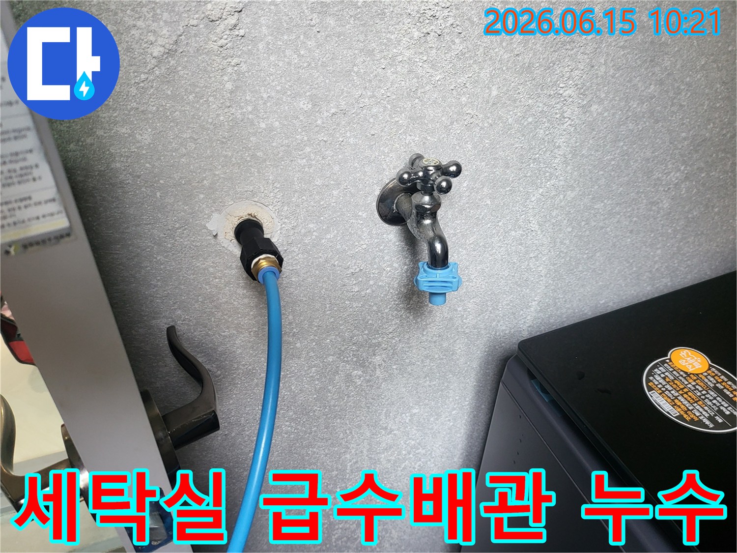 회색 벽에 연결된 파란색 급수 호스와 수도꼭지-세탁실 배관 누수 점검 현장
