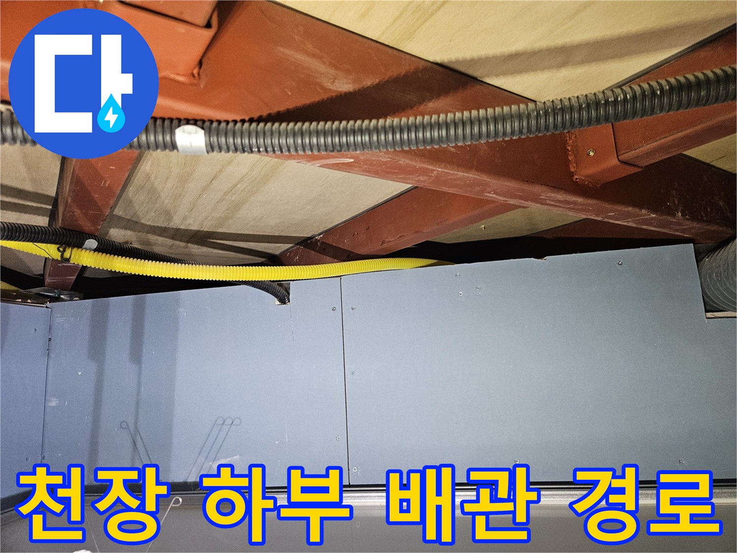 붉은색 구조물 사이의 노란색 배관 및 검은색 전선