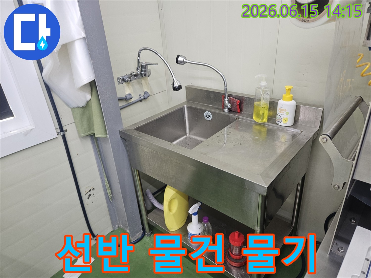 스테인리스-싱크대-위-선반에-놓인-물건에서-물이-떨어져-싱크대에-물기가-생긴-것을-점검하는-누수-전문가의-모습